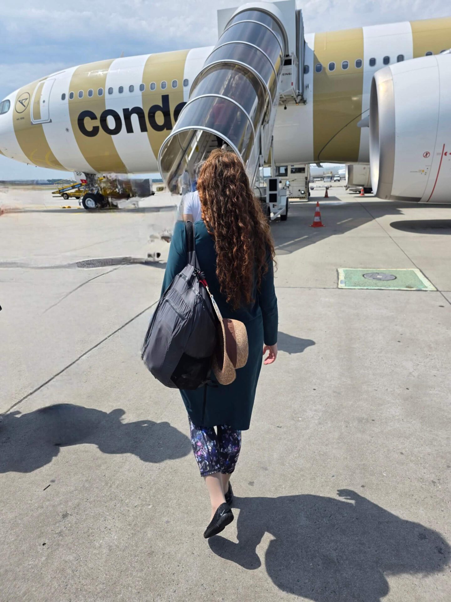 Woman boarding a Condor Airbus A330neo for a Premium Economy long-haul flight